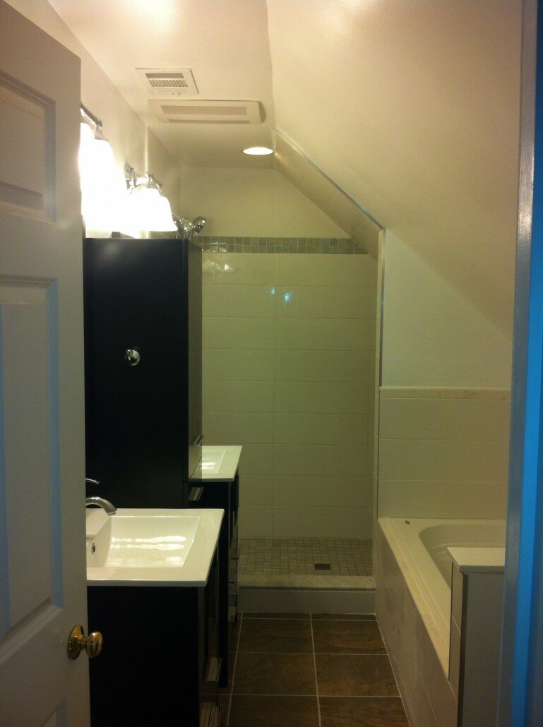 bathroom remodeling Bathroom Remodeling - Black Vanity - Dark Brown Flooring - Bath Tub and White Sink